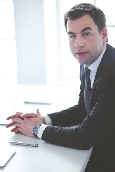 Portrait de jeune homme assis à son bureau dans le bureau. — Photo