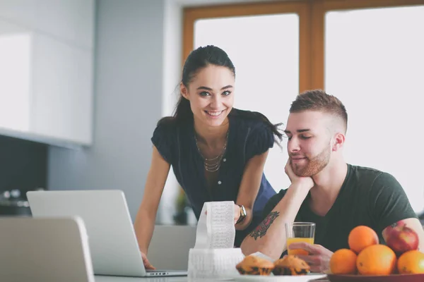 Paret betalar sina räkningar med laptop i köket hemma — Stockfoto