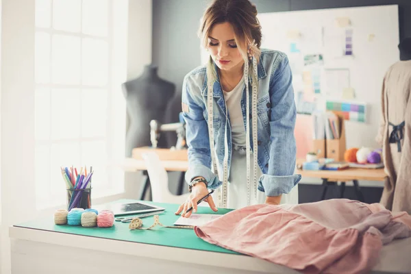 Mulher designer de moda trabalhando em seus projetos no estúdio — Fotografia de Stock