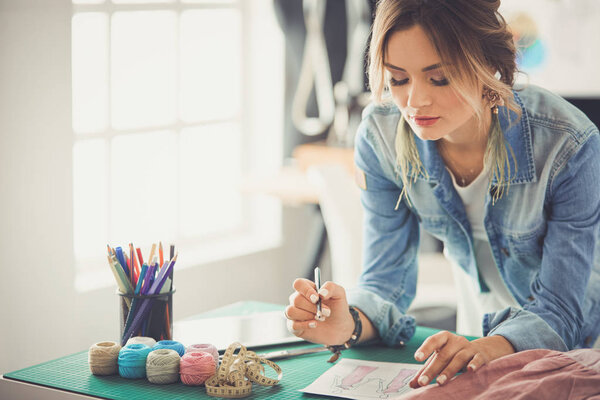 Модный дизайнер женщина работает над своим дизайном в студии