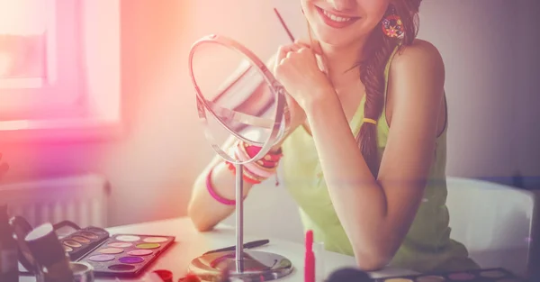 Junge schöne Frau schminkt sich in Spiegelnähe — Stockfoto