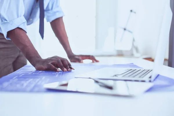 Arquitecto afroamericano trabajando con computadoras y planos en la oficina —  Fotos de Stock