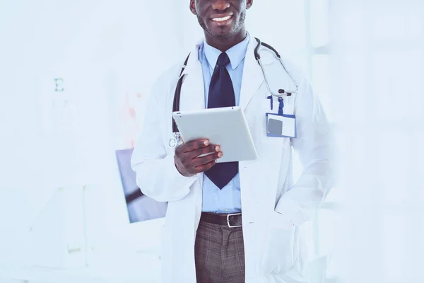 Trabajador médico negro masculino con tableta de pie en el hospital — Foto de Stock