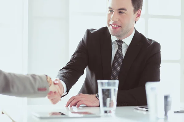 Porträt eines jungen Mannes, der an seinem Schreibtisch im Büro sitzt. — Stockfoto