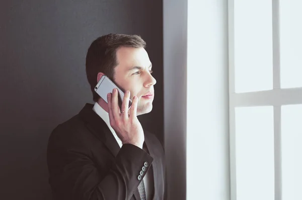 Beau homme d'affaires parlant sur téléphone portable dans le bureau moderne. — Photo