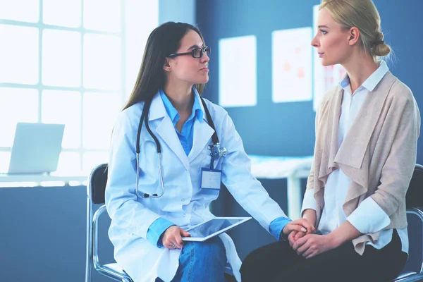 Médico e paciente discutindo algo enquanto se senta na mesa. Conceito de medicina e cuidados de saúde — Fotografia de Stock