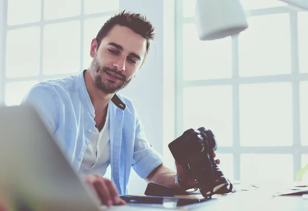 Porträt eines jungen Designers, der im Grafikstudio vor Laptop und Computer sitzt, während er online arbeitet. — Stockfoto