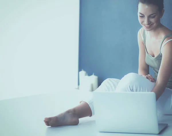 Attraente ragazza caucasica seduta sul pavimento con computer portatile — Foto Stock