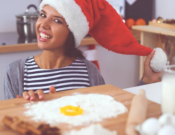 Mutlu genç bayan gülümsüyor Noel hazırlıklarıyla eğleniyor Noel Baba şapkası takıyor. — Stok fotoğraf