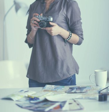 Masada dizüstü bilgisayarla oturan kadın fotoğrafçı.