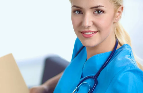 Retrato de un joven médico feliz sentado en el sofá con la carpeta — Foto de Stock