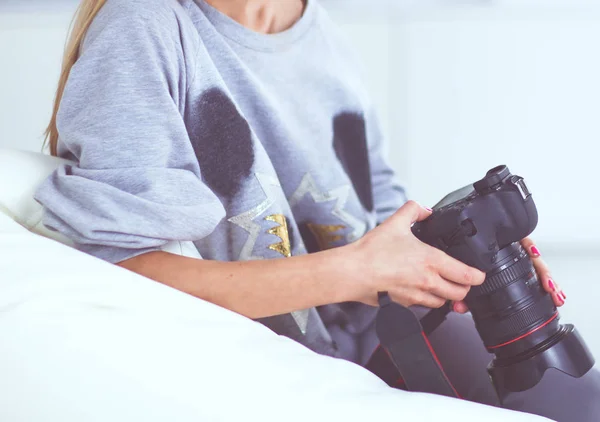 Vrouw zitten op een sofa in haar huis met camera — Stockfoto