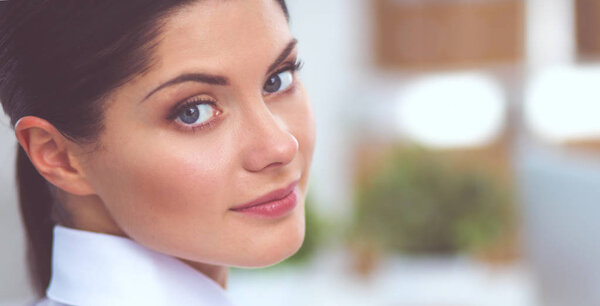 Привлекательная деловая женщина, сидящая на столе в офисе