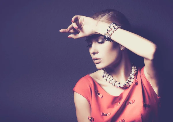 Portrait of young woman on red dress, isolated black background — Stock Photo, Image