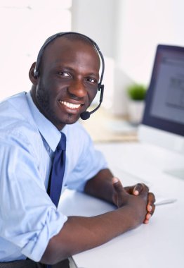 Kulaklıklı Afro-Amerikan işadamı laptopuyla çalışıyor.