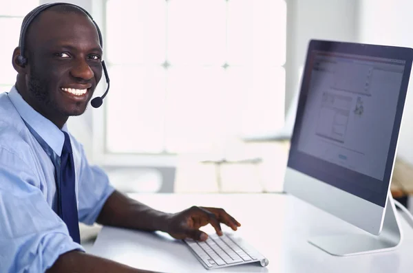 Homme d'affaires afro-américain sur casque de travail sur son ordinateur portable — Photo