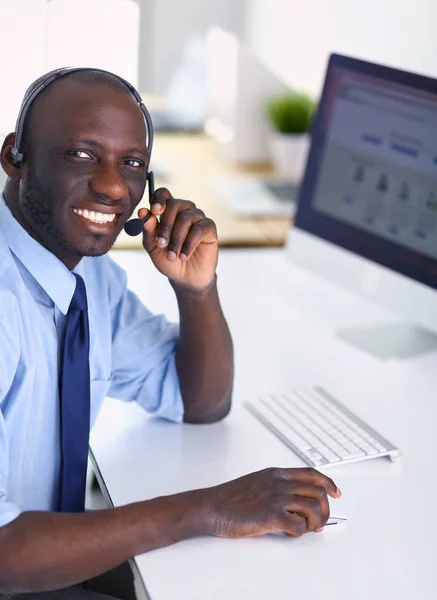 Afrikansk amerikansk affärsman på headset arbetar på sin bärbara dator — Stockfoto