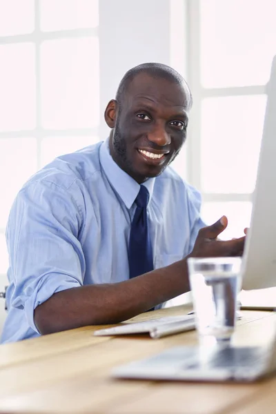 Afrikai amerikai üzletember headseten dolgozik a laptopján — Stock Fotó
