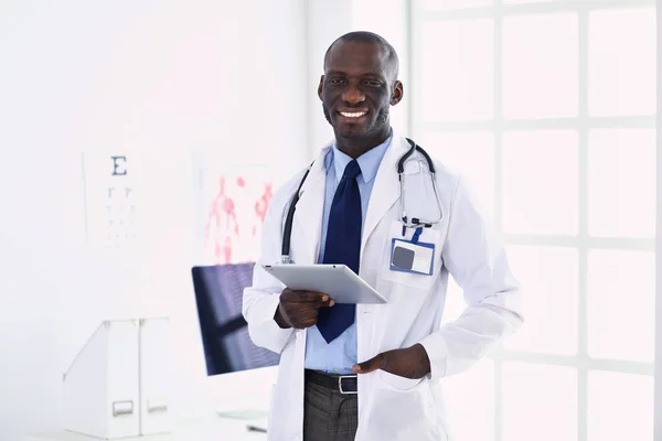 Trabajador médico negro masculino con tableta de pie en el hospital — Foto de Stock