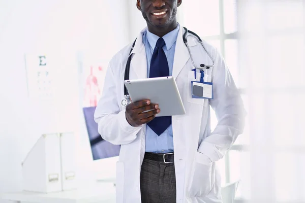 Trabajador médico negro masculino con tableta de pie en el hospital — Foto de Stock