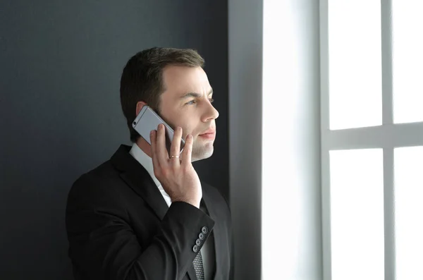 Bonito homem de negócios falando no telefone celular no escritório moderno. — Fotografia de Stock