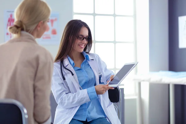 Doktorn och patienten diskuterar något när de sitter vid bordet. Medicin och hälsovård — Stockfoto