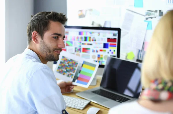 Porträt eines jungen Designers, der im Grafikstudio vor Laptop und Computer sitzt, während er online arbeitet. — Stockfoto