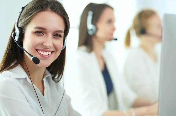 Mujer de negocios sonriente u operador de línea de ayuda con auriculares y computadora en la oficina — Foto de Stock