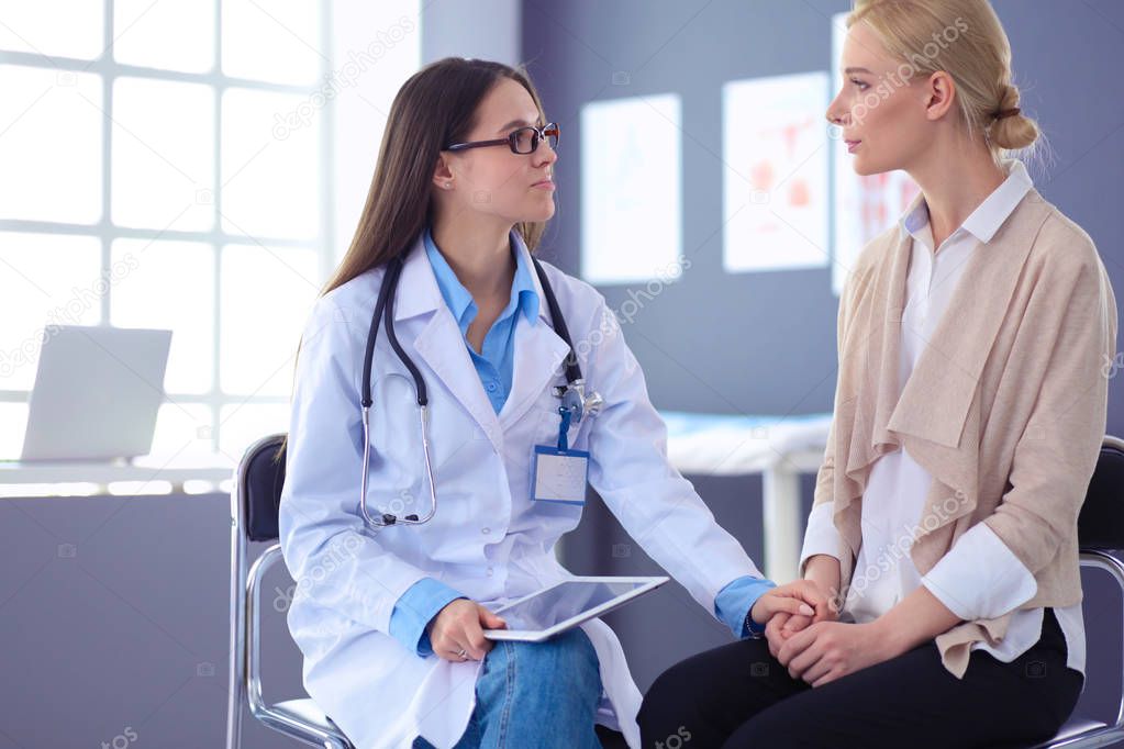 Doctor and patient discussing something while sitting at the table . Medicine and health care concept