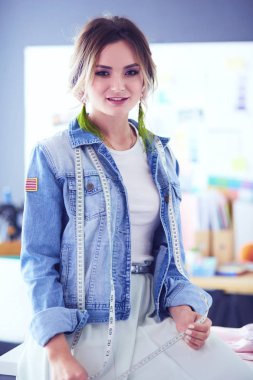 Moda tasarımcısı kadın stüdyoda tasarımları üzerinde çalışıyor.