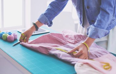 Moda tasarımcısı kadın stüdyoda tasarımları üzerinde çalışıyor.