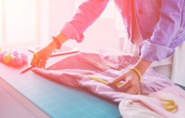 Moda tasarımcısı kadın stüdyoda tasarımları üzerinde çalışıyor.