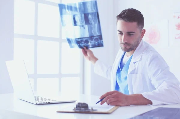 Schöner Arzt spricht mit junger Patientin und macht sich Notizen, während er in seinem Büro sitzt. — Stockfoto