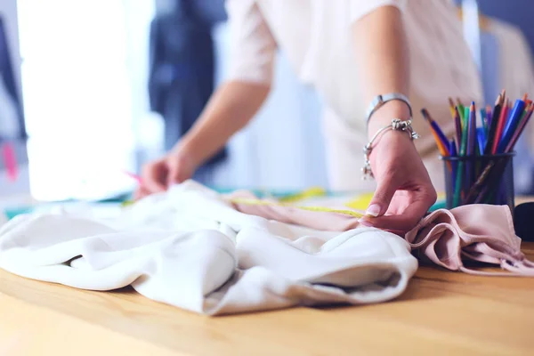 Diseñadora de moda mujer trabajando en sus diseños en el estudio. —  Fotos de Stock