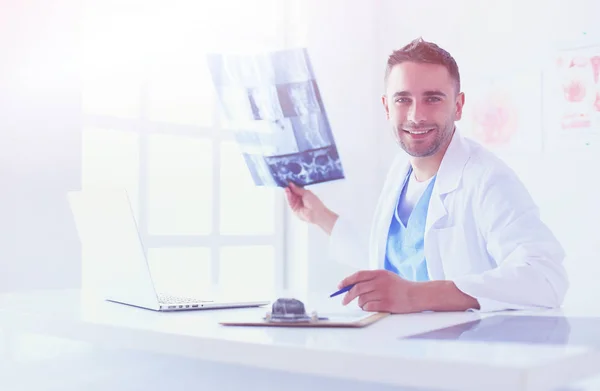 Schöner Arzt spricht mit junger Patientin und macht sich Notizen, während er in seinem Büro sitzt. — Stockfoto