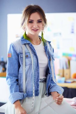 Moda tasarımcısı kadın stüdyoda tasarımları üzerinde çalışıyor.