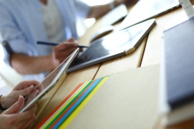İnternette çalışırken bilgisayarın ve dizüstü bilgisayarın önünde grafik stüdyosunda oturan genç tasarımcının portresi.
