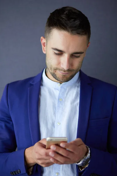 Joven empresario sentado aislado sobre fondo gris. —  Fotos de Stock