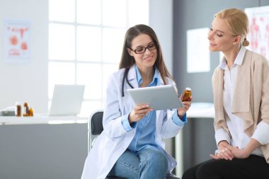 Doktor ve hasta masada otururken bir şey tartışıyorlar. İlaç ve sağlık hizmetleri kavramı