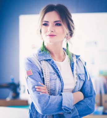 Moda tasarımcısı kadın stüdyoda tasarımları üzerinde çalışıyor.