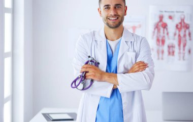 Elinde kahve fincanı olan genç bir doktor.