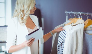 Moda tasarımcısı kadın stüdyoda tasarımları üzerinde çalışıyor..