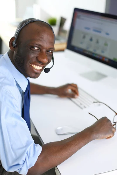 Homme d'affaires afro-américain sur casque de travail sur son ordinateur portable — Photo