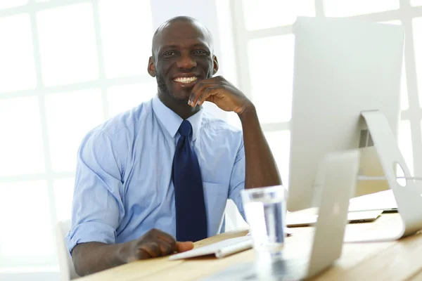 Afrikaans Amerikaans zakenman op headset werken op zijn laptop — Stockfoto