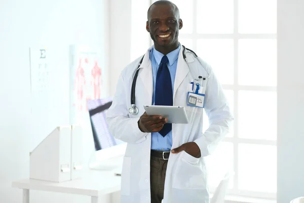 Man svart läkare arbetare med tablett dator stående på sjukhus — Stockfoto