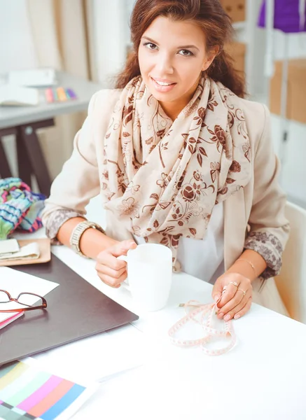 Junge Modedesignerin arbeitet im Atelier. — Stockfoto