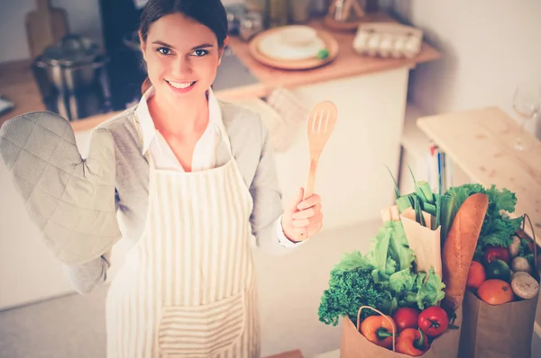 Mulher fazendo comida saudável em pé sorrindo na cozinha — Fotografia de Stock