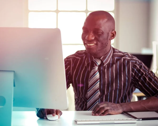 Stilig Afro amerikansk affärsman i klassisk kostym är att använda en laptop och leende medan arbetande i kontor — Stockfoto