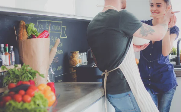 Bir çift evdeki mutfaklarında birlikte yemek pişiriyor.