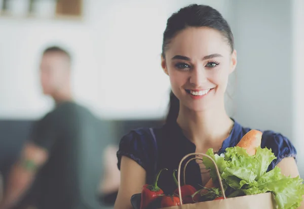 Jong stel in de keuken, vrouw met een zak boodschappen doen — Stockfoto